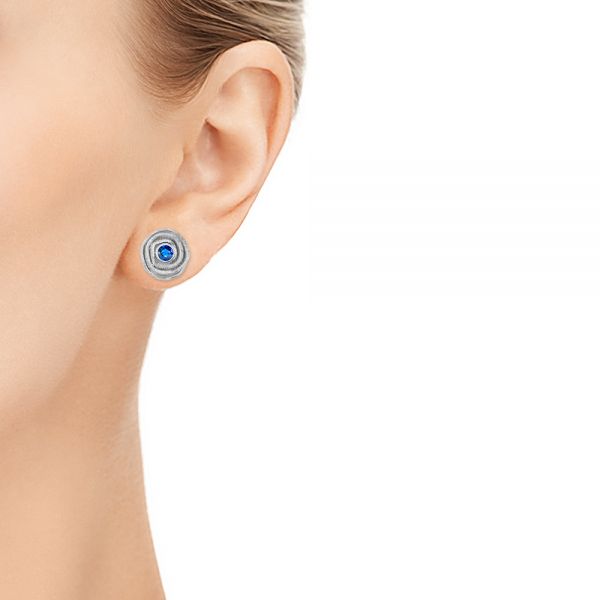 Scroll Stud Earrings With Bezel Set Blue Sapphire - Hand View -  107233